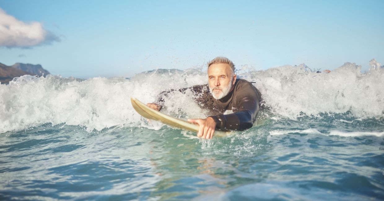 a senior man bodyboarding in the surf. a senior man bodyboarding in the surf.