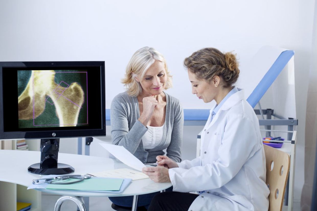 A doctor and patient looking at x-rays. A doctor and patient looking at x-rays.