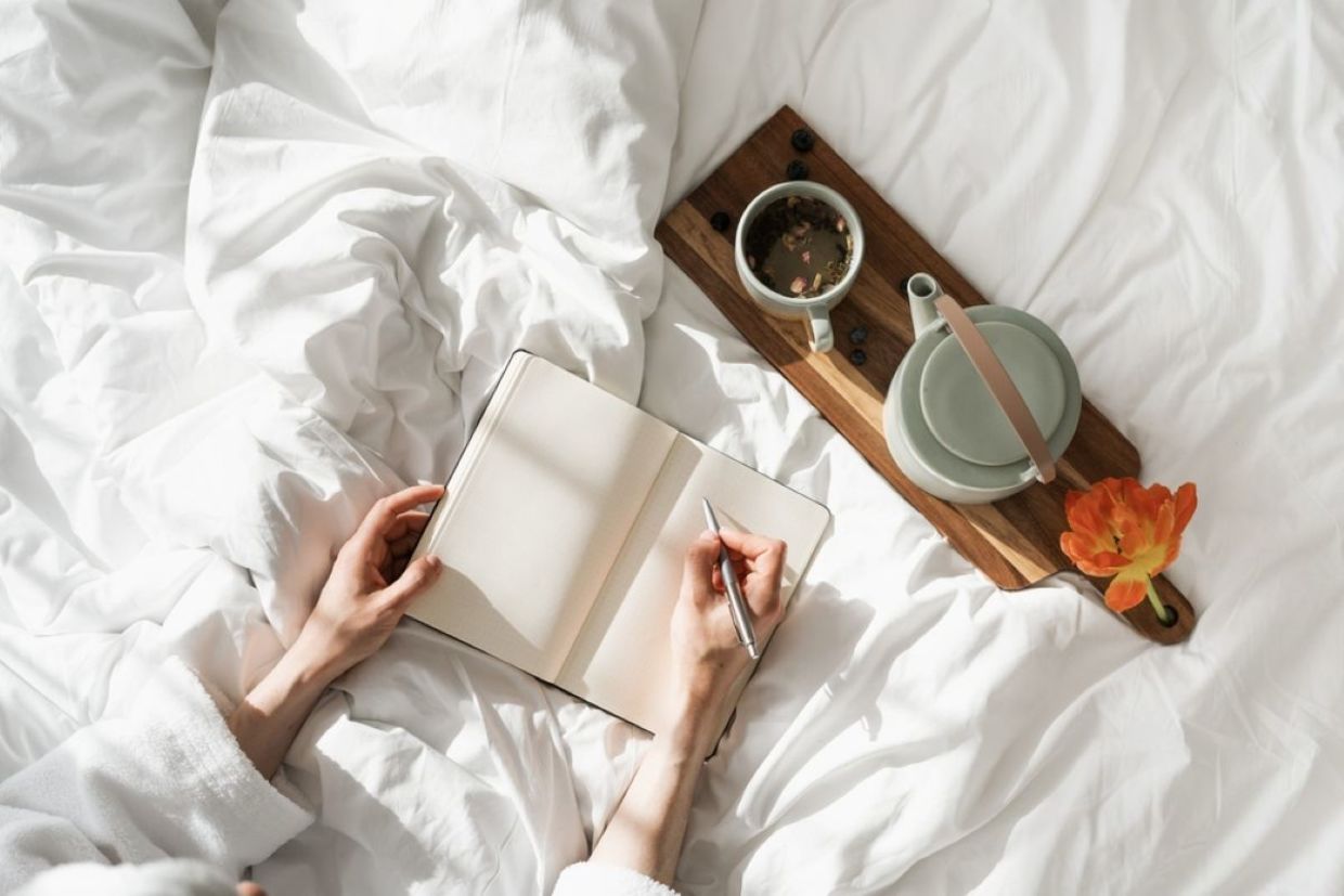 A person journals during the daytime. A person journals during the daytime.