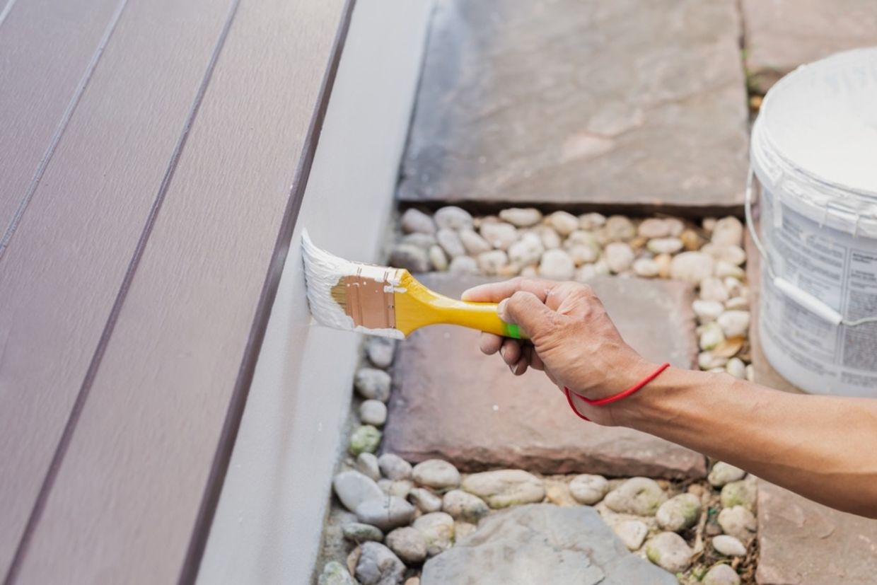 A person paints a structure.
